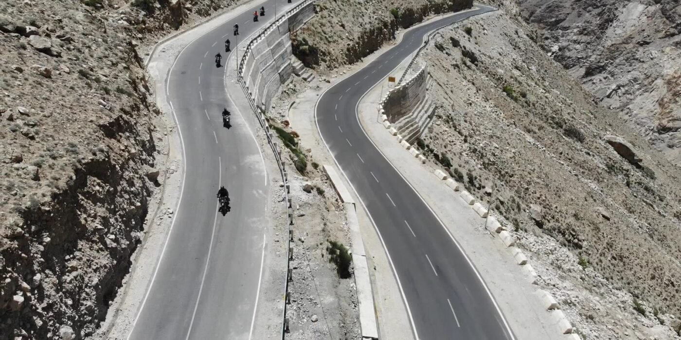 Group of motorcyclists riding the hairpin bends of a mountain road in Spiti Valley, Himachal Pradesh
