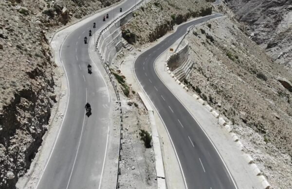 Group of motorcyclists riding the hairpin bends of a mountain road in Spiti Valley, Himachal Pradesh
