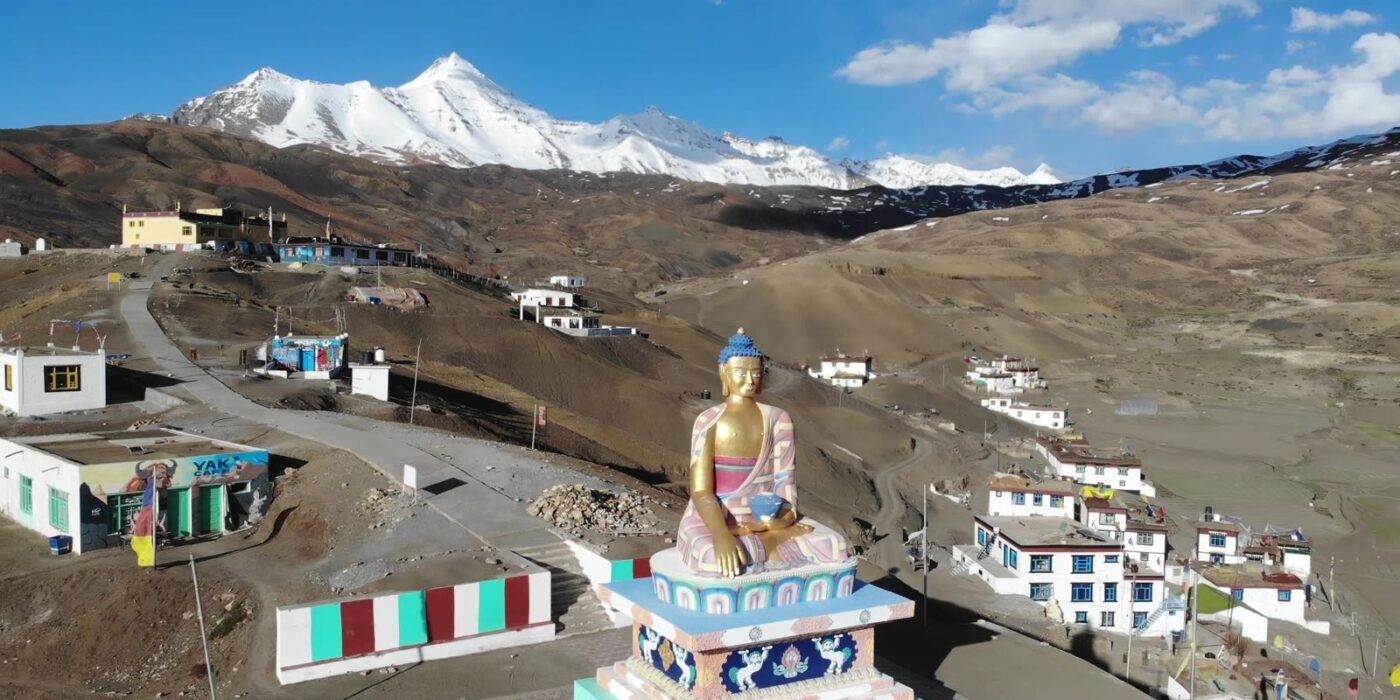 Golden Buddha statue at Langza village in Spiti Valley with snow-capped peaks behind