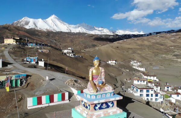 Golden Buddha statue at Langza village in Spiti Valley with snow-capped peaks behind